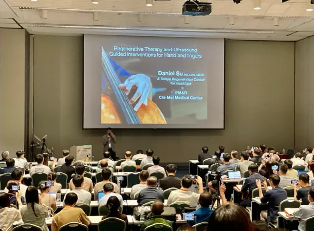 Dr. Su presenting on regenerative therapy and ultrasound-guided interventions for the hand to a large conference audience
